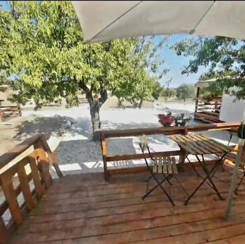 una terrazza in legno con tavolo da picnic e ombrellone di FeudoMallav nice roulotte b&b Noto a Noto