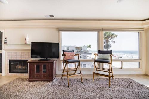 a living room with two chairs and a flat screen tv at Luxury Penthouse with Elevator - Sleeps 10+ - Family Friendly Sun / Surf / Sand in San Diego