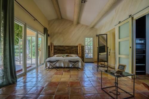 une chambre avec un lit dans une pièce avec des fenêtres dans l'établissement Maison de Charme au Pays de Cézanne, à Aix-en-Provence