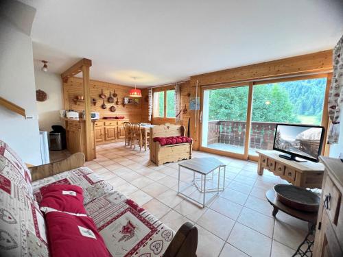 un salon avec un canapé et une table dans l'établissement Tendieu Soleil B - Appartement dans chalet, vue montagnes, à La Clusaz
