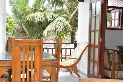 a patio with a table and chairs and palm trees at UR Villa in Waskaduwa
