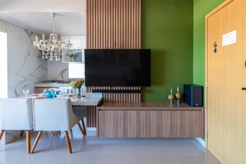 a dining room with a television on a wall at PALMAS EXPERIENCE - APARTAMENTO SUBLIME, vista incrível, em frente ao shopping in Palmas