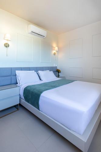 a bedroom with a large white bed with a blue headboard at PALMAS EXPERIENCE - APARTAMENTO SUBLIME, vista incrível, em frente ao shopping in Palmas