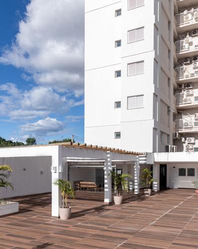 a white building with potted plants in front of it at PALMAS EXPERIENCE - APARTAMENTO SUBLIME, vista incrível, em frente ao shopping in Palmas