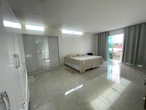 a white bedroom with a bed and a glass shower at Casa Festival de Parintins 2025 com vista para o Bumbodromo in Parintins