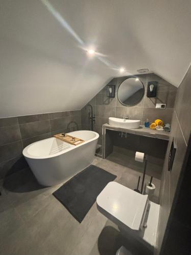 a bathroom with a tub and a toilet and a sink at ARKANA Rydzewo in Rydzewo