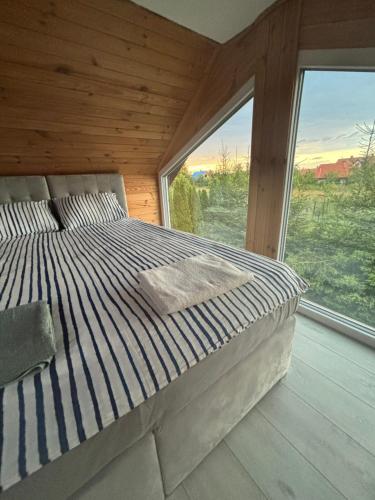 a bed in a room with a large window at ARKANA Rydzewo in Rydzewo