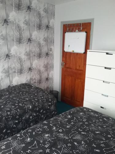 a bedroom with a bed and a wall with trees at medium sized room in my bungalow in Great Clacton