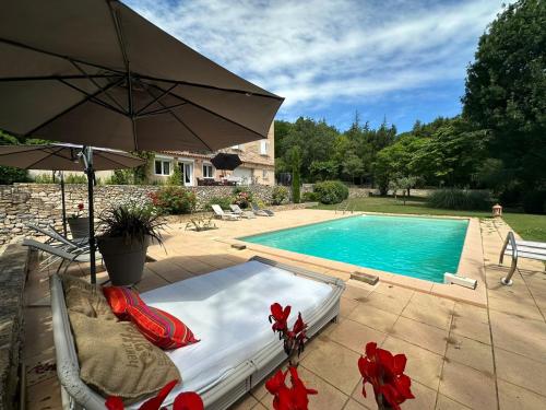 - une piscine avec un lit et un parasol à côté dans l'établissement Domaine de Casamène, à Auriol