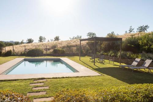 a swimming pool in the middle of a yard at Luminoso Fienile vista vigne in Castiglioni