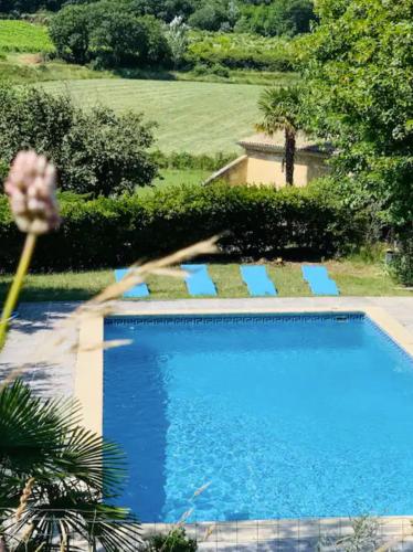 une grande piscine bleue dans une cour dans l'établissement Les Citronniers, à Saint-Montan