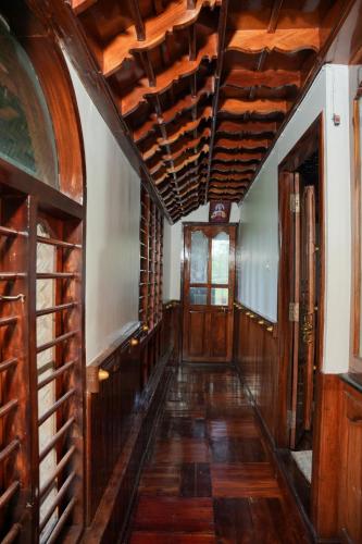 an empty hallway with wooden floors and wooden ceilings at Rajahamsam Houseboat in Kumarakom