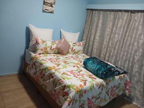 a bed with pillows and avertisement at Arcon Guest House in Vanderbijlpark
