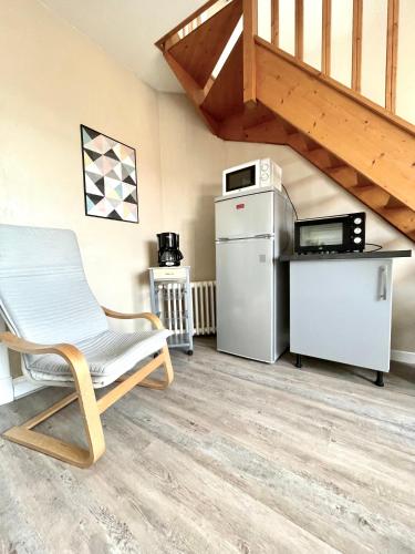 une pièce avec une chaise, un réfrigérateur et un micro-ondes dans l'établissement Duplex tout confort dans Boulogne, à Boulogne-sur-Mer