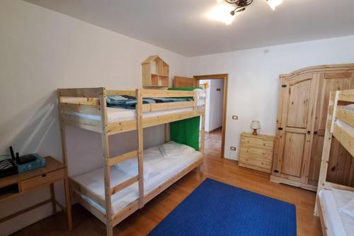 a room with two bunk beds and a blue rug at Sveta apartment Auronzo in Auronzo di Cadore