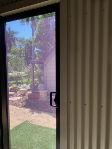 a sliding glass door with a view of a yard at Shauna's Shack in Katherine