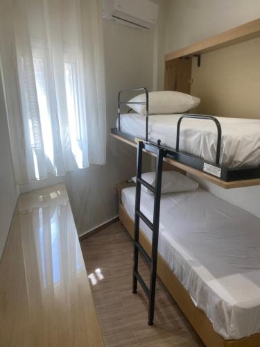 two bunk beds in a small room with a window at Lissos Rooms Sougia in Sougia