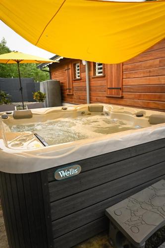 a large jacuzzi tub with a yellow umbrella at Villa Citala avec Piscine et Jacuzzi privé in Le Marin
