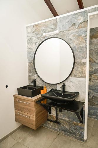 a bathroom with a black sink and a mirror at Villa Citala avec Piscine et Jacuzzi privé in Le Marin