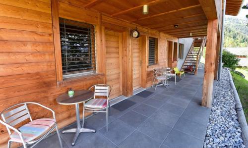a porch of a cabin with chairs and a table at Chalet Tzarbonire in Chalais