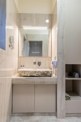 a bathroom with a sink and a large mirror at Armenopetra View Gerolimenas in Gerolimenas