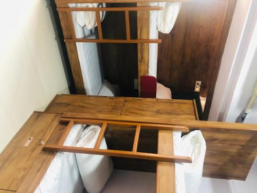 a room with a wooden bunk bed with a table at Everest Stays Rooms and Dormitory in Mumbai