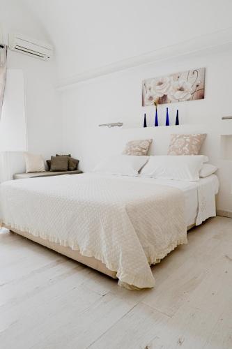 a white bedroom with a large bed with white sheets at Miro B&B in Lecce