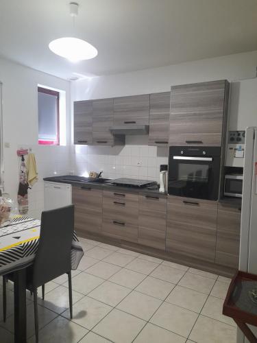 une cuisine avec des placards en bois, une table et une table sidx sidx sidx dans l'établissement Maison 14 personnes,Pal 4 kms, à Thiel-sur-Acolin