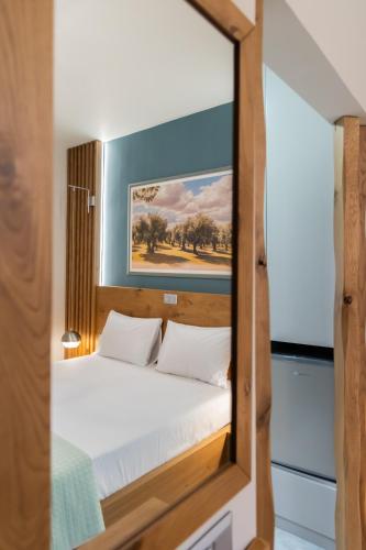 a bedroom with a bed with a mirror at Armenopetra View Gerolimenas in Gerolimenas