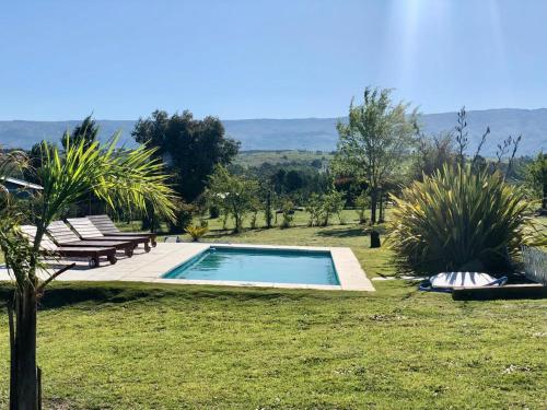 a swimming pool in the middle of a grassy yard at Cabaña Snowflakes in Villa Yacanto