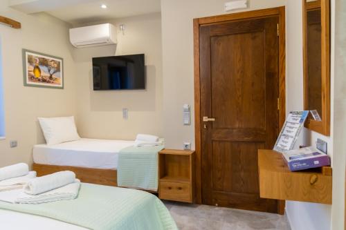 a room with two beds and a door at Armenopetra View Gerolimenas in Gerolimenas