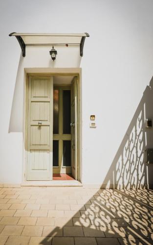 a white house with a door and a staircase at Miro B&B in Lecce