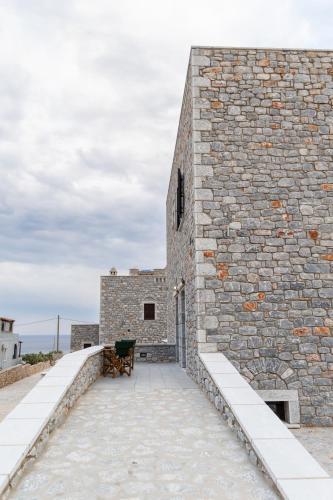 a stone building with a bench in front of it at Armenopetra View Gerolimenas in Gerolimenas