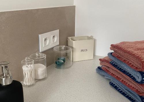 a bathroom with towels and a box on the floor at Gîte cosy et tout équipé "Une cabane en Luberon" 44 m2 avec jardin in Pertuis