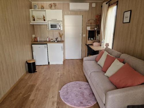 un salon avec un canapé et une cuisine dans l'établissement Le Chalet Marceau, à Carrières-sur-Seine