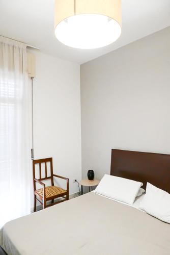 a bedroom with a white bed and a chair at Miro B&B in Lecce