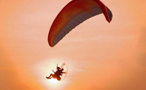 a person riding a parachute in the sky at Desert Dream Royal Camp & Pool in Jaisalmer