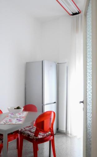 a dining room with a white table and red chairs at Miro B&B in Lecce