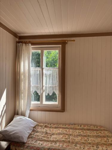 a bedroom with a bed and a window at Auberge du Jardin in Petit-Saguenay