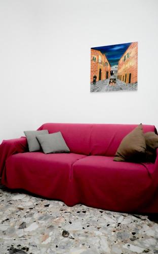 a red couch in a room with a picture on the wall at Miro B&B in Lecce
