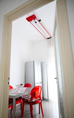 a dining room with a table and red chairs at Miro B&B in Lecce