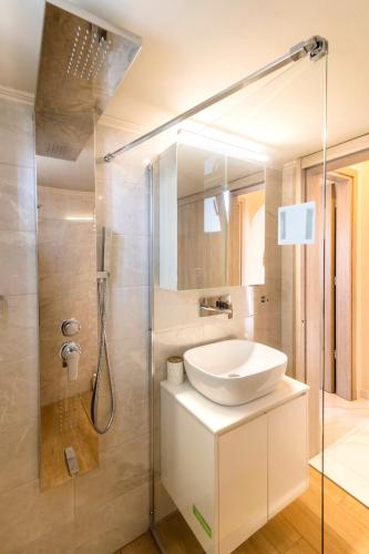 a bathroom with a sink and a shower at Nikargy Luxury Apartments in Koskinou