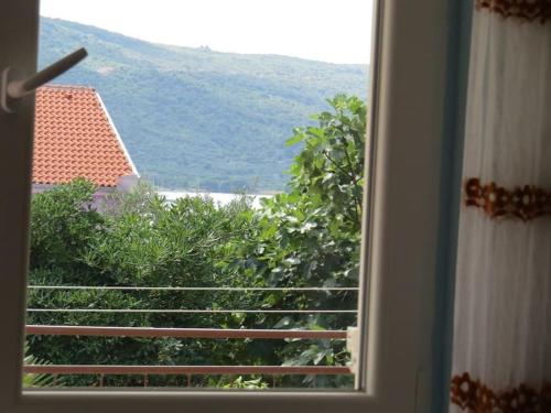 a window with a view of a mountain at Apartment Radanović-Beaches 5 min walking in Cres