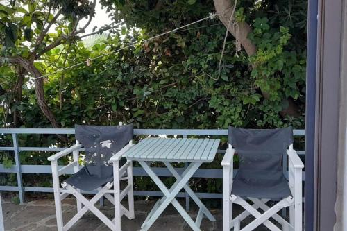 a picnic table and two chairs sitting next to a fence at xanthoula's house in Agios Kirykos