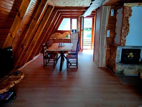 a dining room with a table and chairs and a fireplace at Romantica Forest Guest House in Dospat