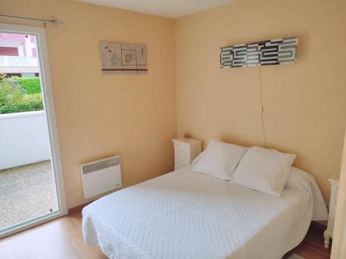 une petite chambre avec un lit et une fenêtre dans l'établissement Beau T2 proche plages et montagnes du Pays-Basque, à Ahetze