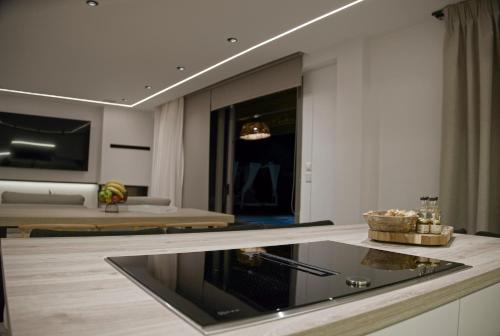 a kitchen with a stove and a living room at Villa Mourelo luxury villa in chania with private pool jacuzzi in Chania Town