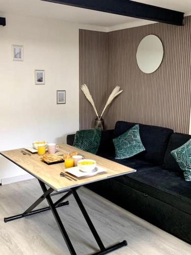un salon avec une table et un canapé dans l'établissement Jolie et agréable appartement proche des plages et de l Espagne, à Perpignan