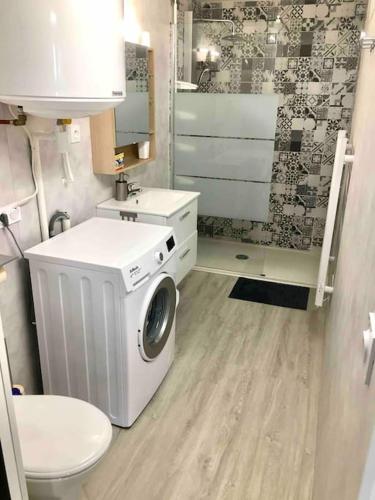 une salle de bain avec machine à laver et toilettes dans l'établissement Jolie et agréable appartement proche des plages et de l Espagne, à Perpignan