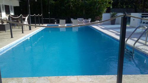 a large blue swimming pool with a metal railing at E&J Boutique Residences in Sosúa